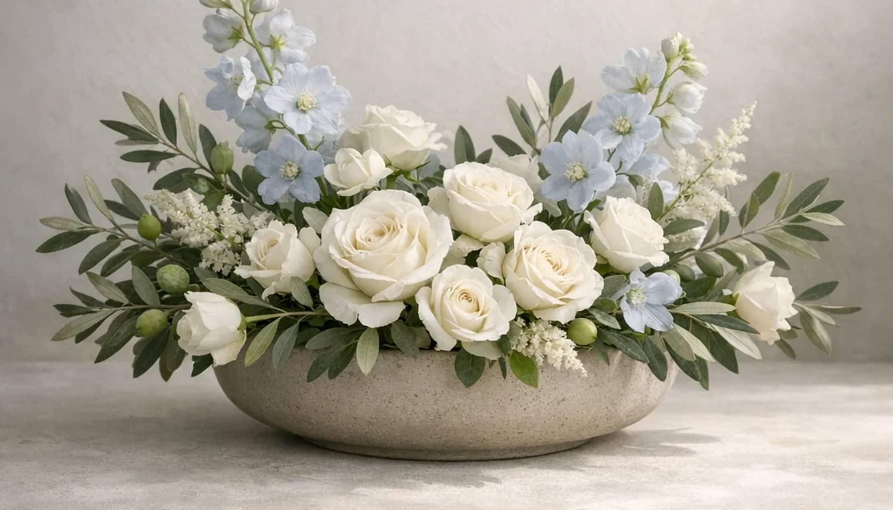 International Day of Conscience flower arrangement with white roses, olive branches, pale blue delphinium designed as a respectful peace and solidarity floral guide