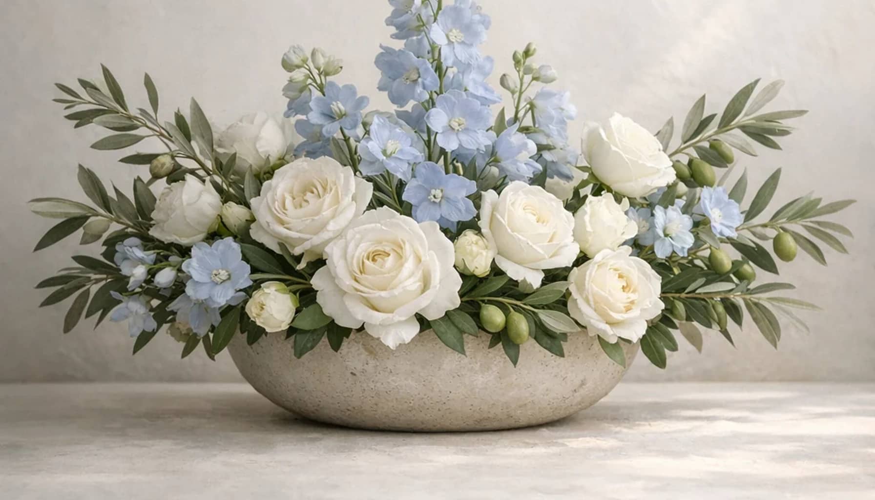 International Day of Peaceful Coexistence flower arrangement with white roses, olive branches, pale blue delphinium designed as a respectful peace and solidarity floral guide