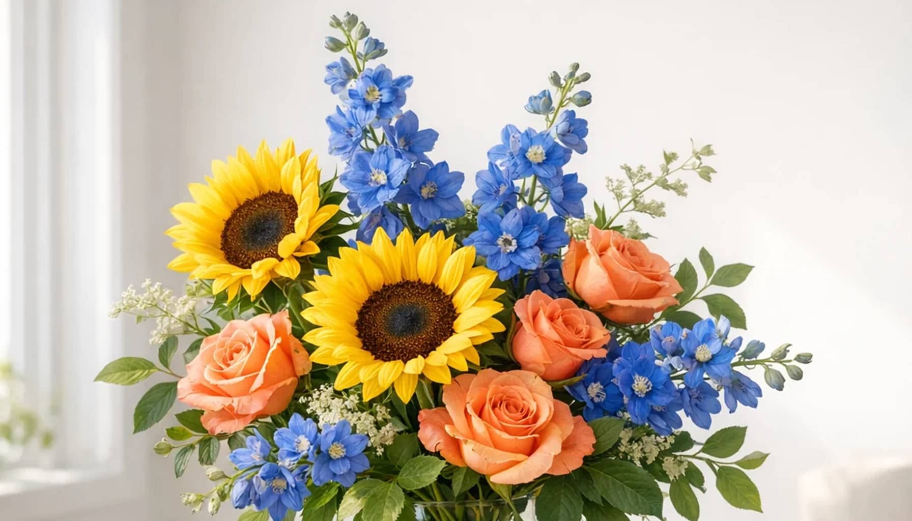 World Autism Awareness Day flower arrangement with sunflowers, coral roses, blue delphinium designed as a respectful community floral guide