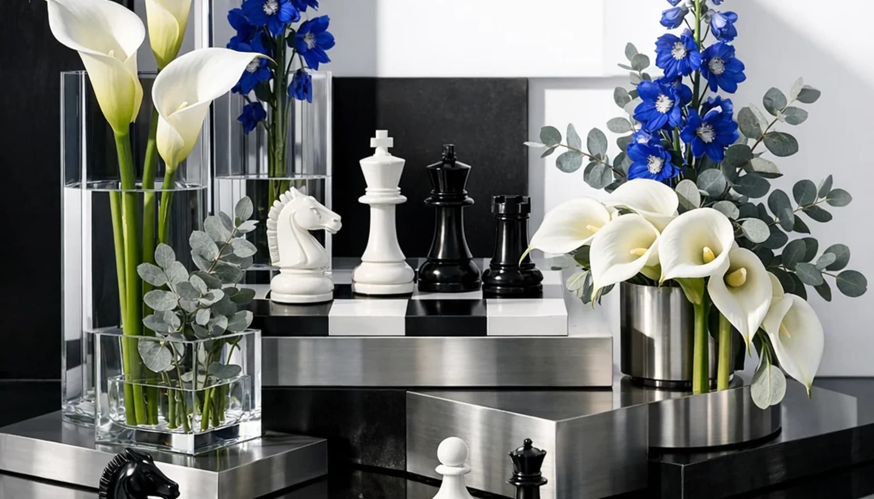 World Chess Day flower guide banner featuring white calla lilies, blue delphinium, silver eucalyptus in optic white, cobalt, silver, green tones