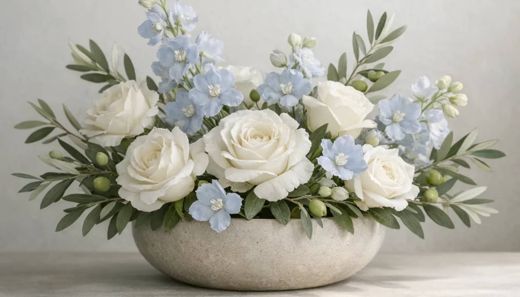 World Day of Social Justice flower arrangement with white roses, olive branches, pale blue delphinium designed as a respectful peace and solidarity floral guide