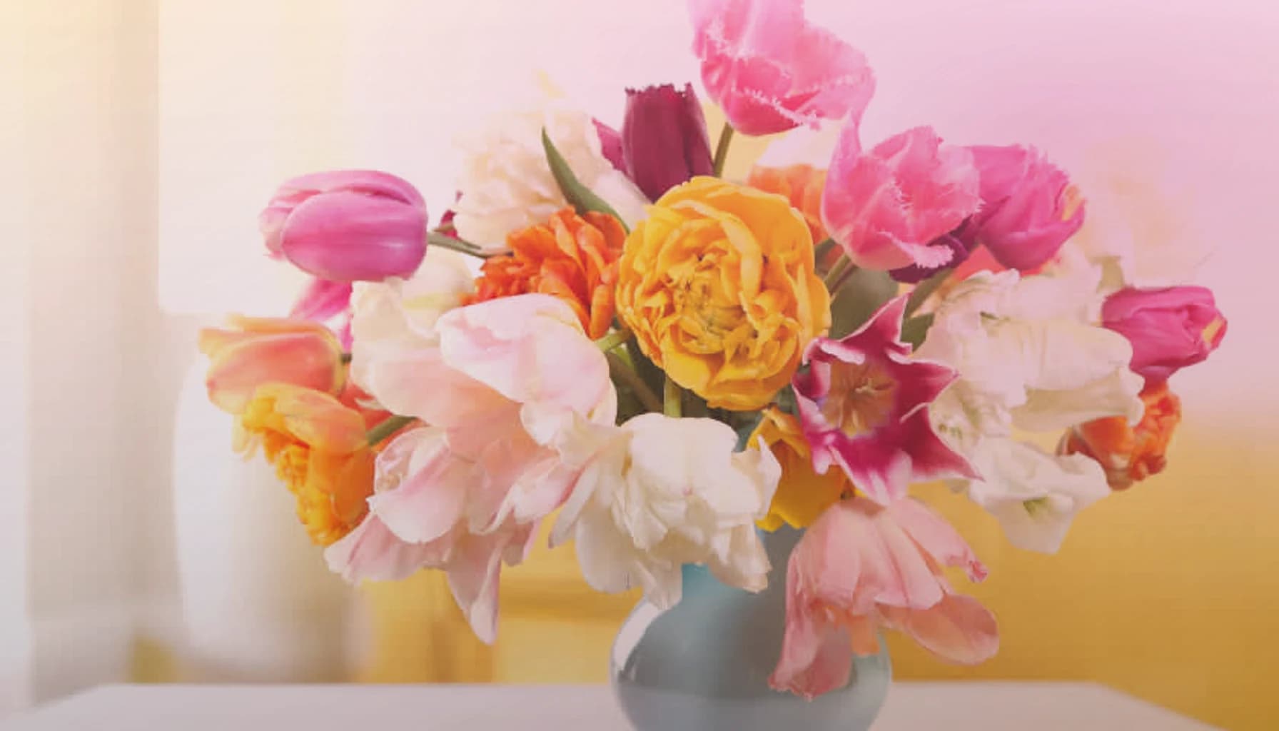 Holi flowers collection banner with marigolds, magenta ranunculus, and orange roses and joyful, abundant, color-saturated, and spring-celebratory styling from Lina Flowers