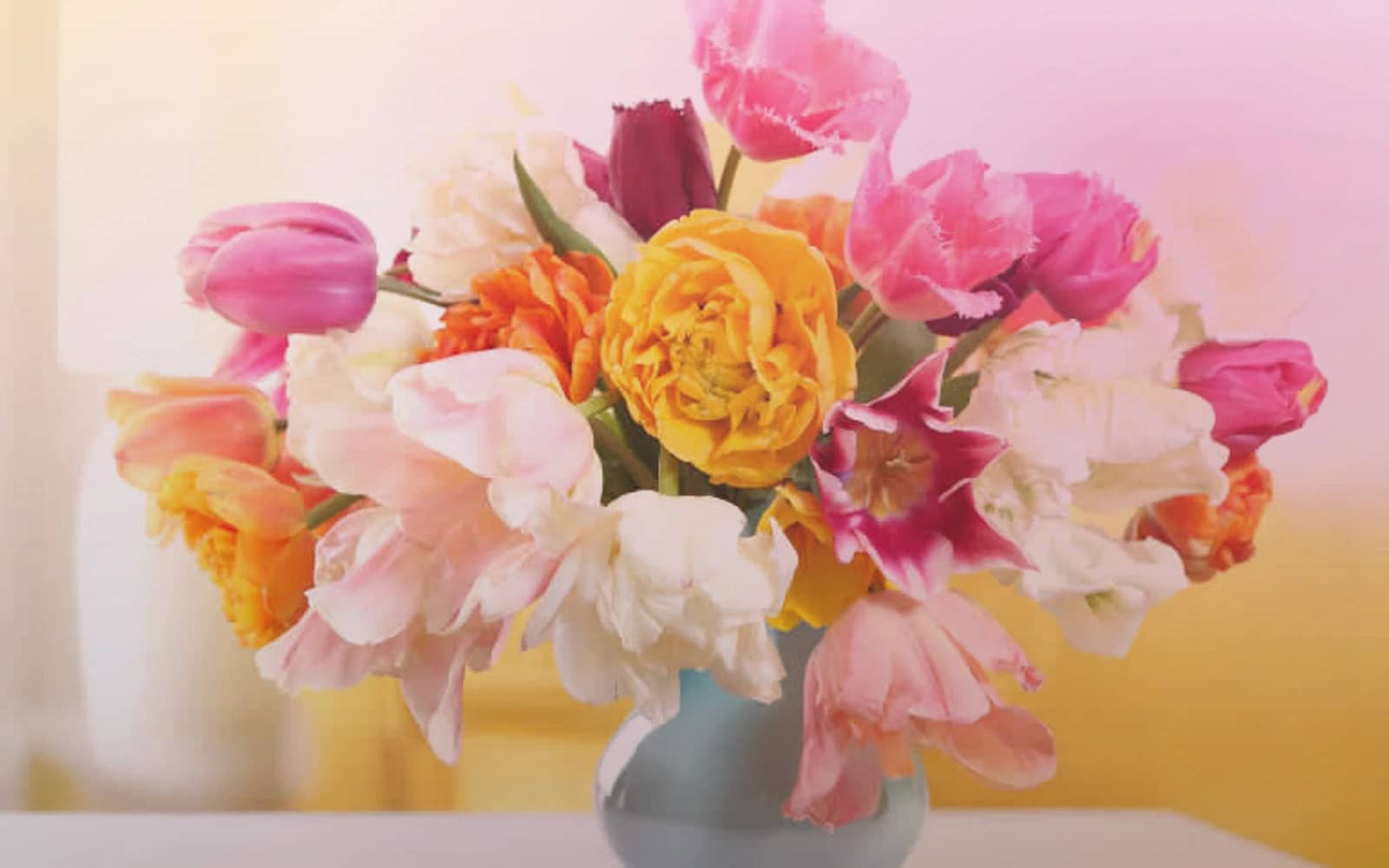 Holi flowers with marigolds, magenta ranunculus, and orange roses, marigold yellow, festival magenta, and saffron orange color direction, and premium joyful, abundant, color-saturated, and spring-celebratory styling from Lina Flowers