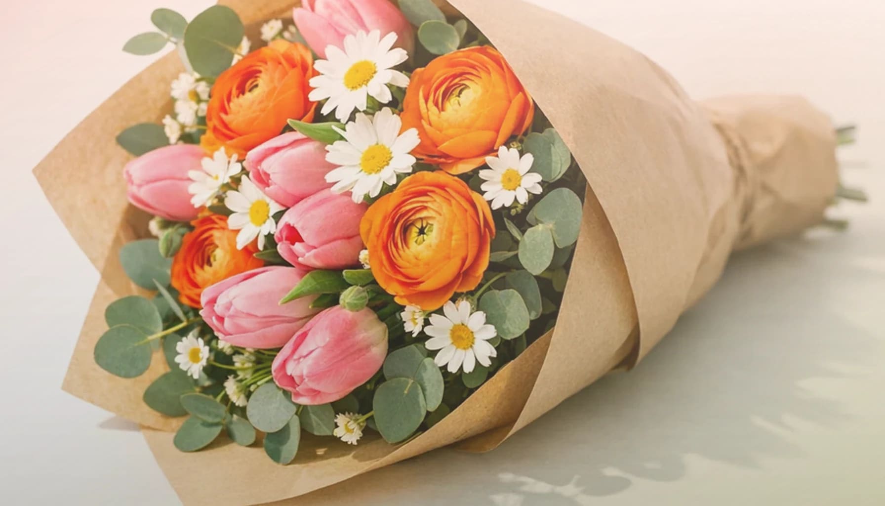 International Friendship Day flowers collection banner with coral garden roses, peach ranunculus, and soft yellow tulips and warm, generous, sincere, and friendship-led styling from Lina Flowers