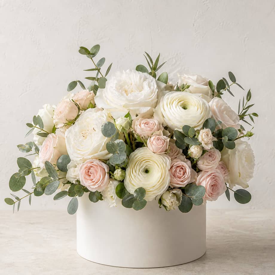 Ivory House white garden rose and cream ranunculus arrangement in a modern ivory flower box