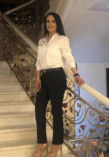 Liana, co-founder of LiNa Garden and Lina Flowers, standing beside an ornate floral staircase