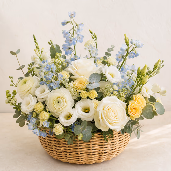 Little Dream new baby flower basket with white roses, pale blue flowers, soft yellow roses, and eucalyptus