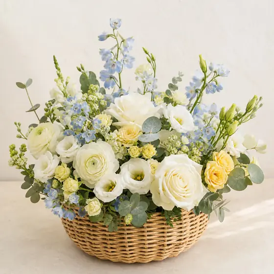 Little Dream new baby flower basket with white roses, pale blue flowers, soft yellow roses, and eucalyptus